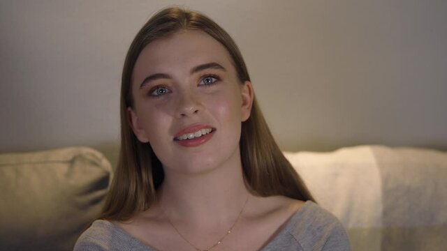 Happy carefree young Caucasian woman looks into camera, slow motion