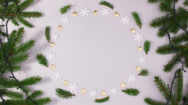 Round frame with snowflakes and stars for text and pine branch with blinking lights. Stop motion