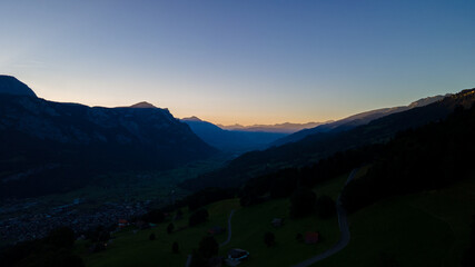 Fototapeta na wymiar Morning Dawn in a valley between beautiful mountain chains in Switzerland- Drone Perspective Landscape Photography