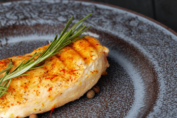 Grilled chicken breast served on black table