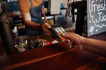 Close up of card payment being made between customer and bartender in cafe