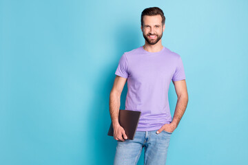 Fototapeta na wymiar Photo portrait of positive programmer wearing casual clothes keeping laptop smiling isolated vivid blue color background empty space