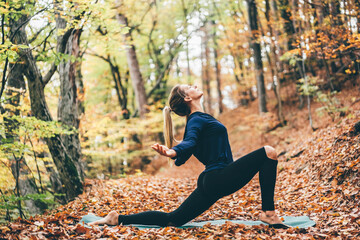 Woman doing yoga pose in peaceful natural forest. Lifestyle and Meditation concept.