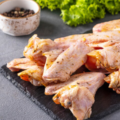 Raw chicken wings marinated in spices. Closeup