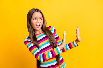 Profile photo of little disgusted girl raise two arms show denial wear striped shirt isolated...