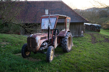 Rosttraktor hinter dem Bauernhaus