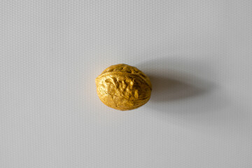 Walnut of golden color on a white background. Photo taken with selective focus and noise effect