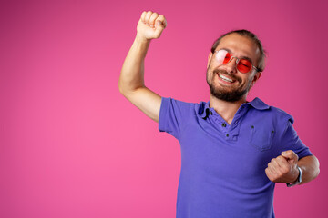 Overjoyed funny bearded man in glasses celebrating success