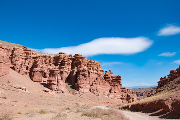 Obraz premium Picturesque view over Charyn canyon, a geological formation of amazing big red sand stone, with vivid blue sky, National natural park in Almaty region, Kazakhstan