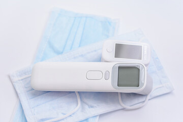 Portable Pulse Oximeter, infrared medical thermometer on Background face mask to monitor oxygen level at home. Covid-19, healthcare concept. Pulse Rate Health Taster