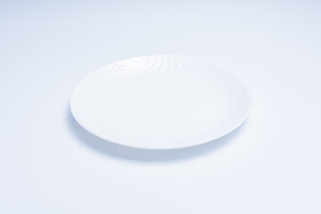 White plate with cutlery on white background