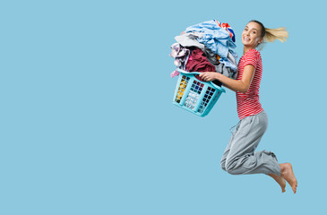 Happy woman doing laundry and jumping - obrazy, fototapety, plakaty