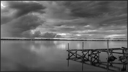 Sunrise and wooden pier in black and white