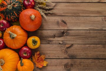 Pumpkins, apples and leaves. Autumn flat lay composition with copy space on wooden background.