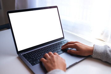 Mockup image of a businesswoman using and typing on laptop computer keyboard with blank white desktop screen on the table