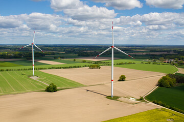 wind turbine, wind farm on a sunny cloudy day shot from eye level, hub height with agricultural landscape below