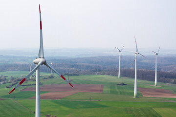 wind turbine, wind farm on a sunny misty morning shot from eye level, hub height with agricultural...