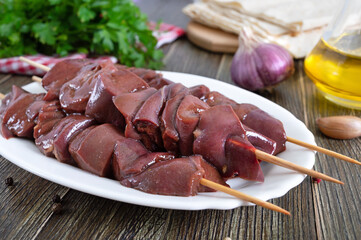 Pieces of raw pork liver on wooden skewers for cooking barbecue. Diet dish. Asian cuisine.