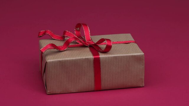 Christmas gift arrives on red background. 4K stop motion animation loop.