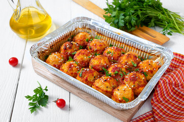 Meatballs in tomato sauce baked in an aluminum foil container. Diet meat dish.