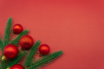 Red Christmas balls with fir branches on a red background