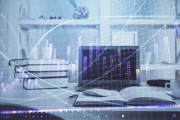 Stock market graph on background with desk and personal computer. Multi exposure. Concept of financial analysis.