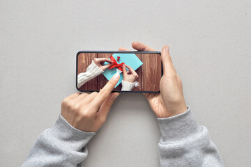 A person watches a master class on gift packaging on the Internet on their phone. Preparing for the...