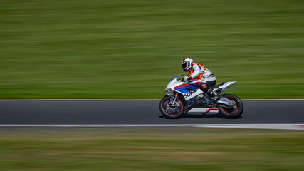 A panning shot of a racing bike cornering on a track.