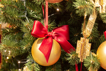 Christmas background with fir tree branches, decorations and blurred lights on back. Close-up view of beautiful christmas tree with colorful balls and illuminated garland