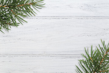 Photo of Christmas tree branches on white wooden background with copy space, border