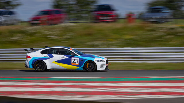 A Panning Shot Of A Racing Car As It Circuits A Track.