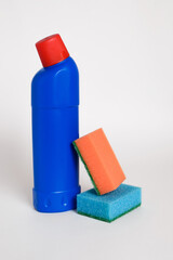 Cleaning agent or disinfectant in blue bottle with  sponges on a white background