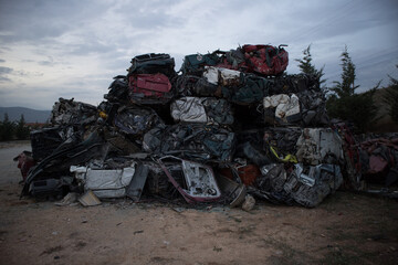 A huge amorphous mass of iron of damaged cars. Awaiting recycling. At a vehicle graveyard.