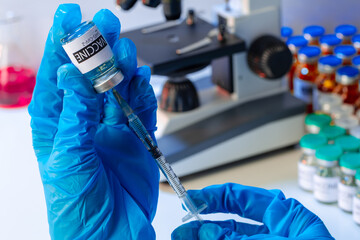 Doctor hands in blue gloves holding Sars-cov-2 vaccine vial