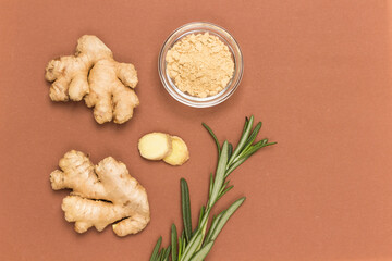 Fototapeta na wymiar Raw ginger root and dry ginger on brown