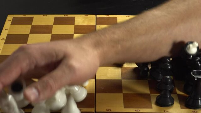 canceling the game of chess, the man sweeps the hand of the figure off the board