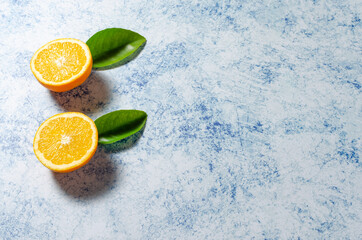 Oranges with their leaves on a blue background