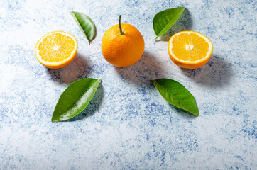 Oranges with their leaves on a blue background