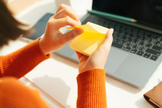 Student opem sticky note for taking note at laptop working desk.