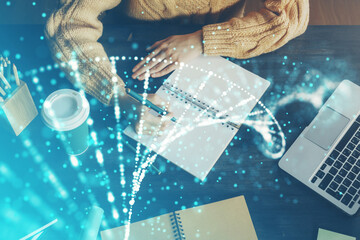 DNA theme hologram over woman's hands writing background. Concept of education. Double exposure