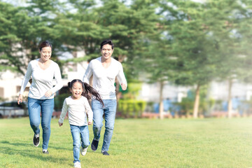 Naklejka na ściany i meble Young attractive happy asian family playing by running together in outside nature park in home school learning or montessori concept with white and blue casual wearing. Asian lifestyle parenting.