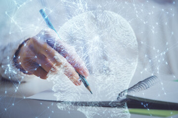 Multi exposure of writing hand on background with brain hologram. Concept of self learning.