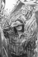 Fototapeta na wymiar Black and white shot of Young woman farmer with corn harvest. Worker holding autumn corncobs. Farming and gardening