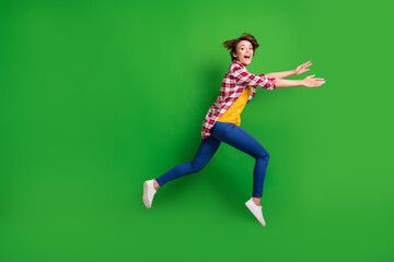 Fototapeta na wymiar Full size profile photo of nice impressed girl jumping run for sale wear trousers shirt sneakers isolated on green color background