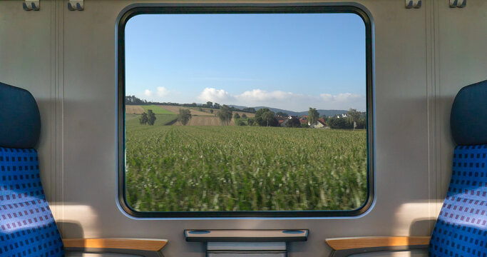 An empty blue seat in europe german train with window corn field display nature summer view on the railway road transportation during coronavirus 