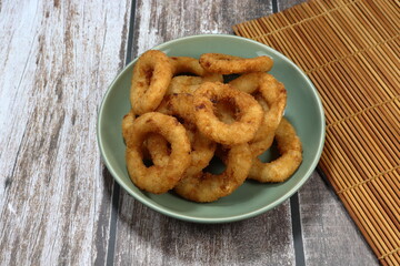 Onion ring, deep fried sliced fresh onion with flour on the plate. Famous snack and appetizer menu in Asia fast food. 