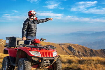 A man on a quad bike in the mountains. 