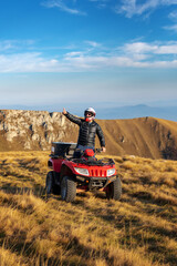 A man on a quad bike in the mountains. 