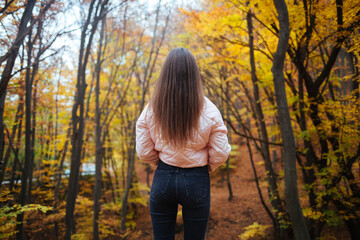 Back view of a young female in the autumn park