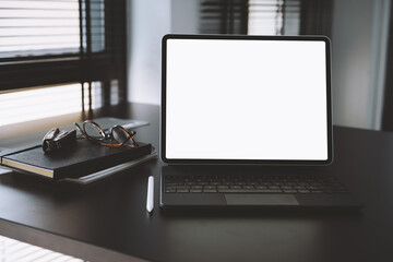 Tablet mockup with blank screen on black table at home office. Home interior or office background